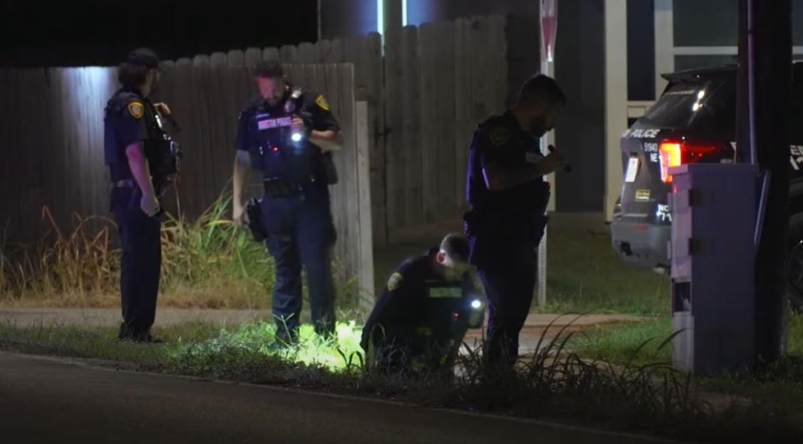 Police officers investigating a scene at night.