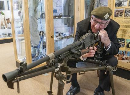 A World War II veteran with a Bren gun at a regimental museum.