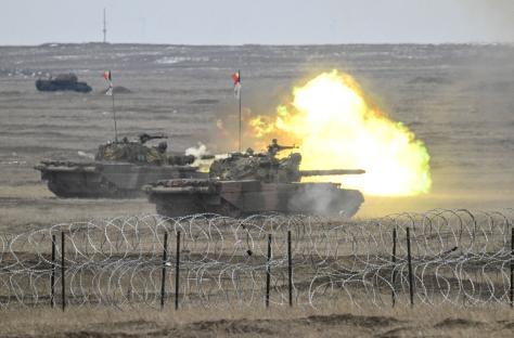 Romanian army tanks firing during a NATO military exercise.