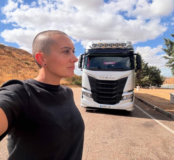 Oti Cabadas, a trucker girl influencer, in front of a white Iveco truck.