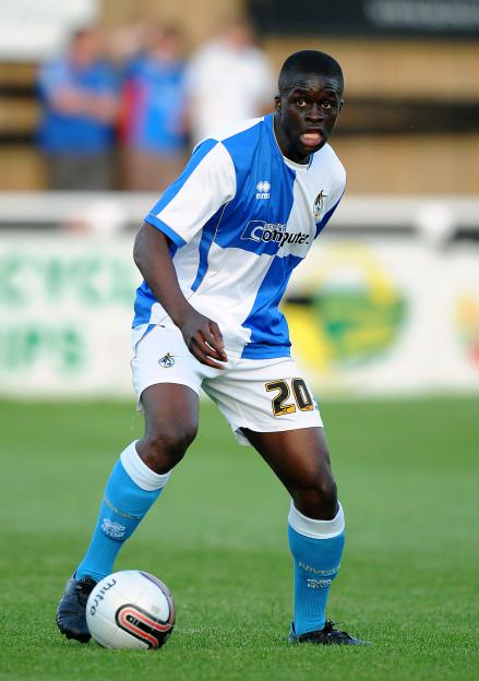 Soccer player in blue and white uniform with ball at feet.