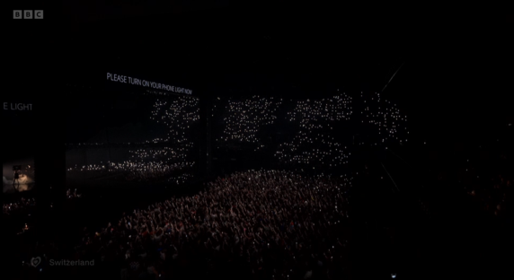 Concert audience with lit-up phones.