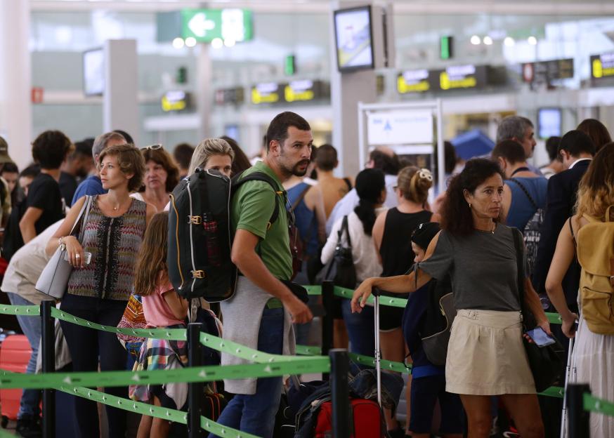 Passengers waiting in line at airport security.