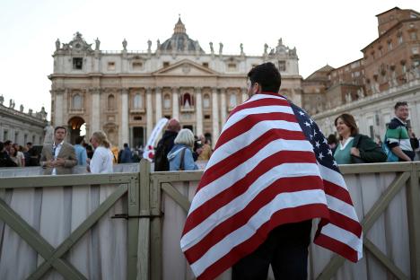Person draped in an American flag in St. Peter's Square.