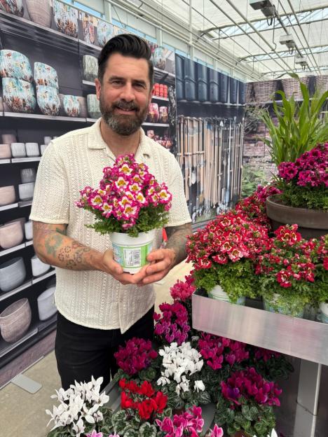 Man holding a potted Schizanthus.