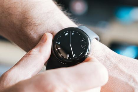 Close-up of a man adjusting a smartwatch on his wrist.
