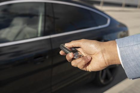 Person unlocking a car with a key fob.