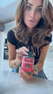 Woman holding a bottle of Omega 3 fish oil.