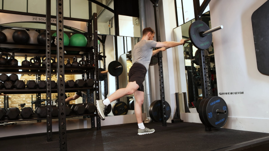 Man performing a leg exercise in a gym.