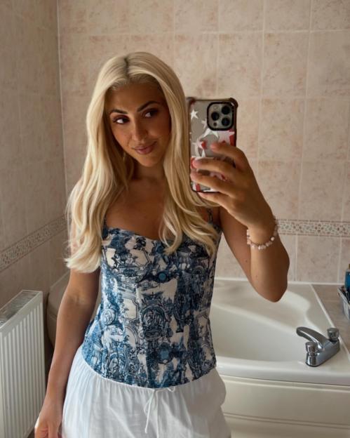 Bianca Petronzi taking a selfie in a bathroom mirror.