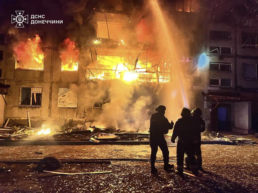 Firefighters putting out a fire in a building after a Russian rocket attack.