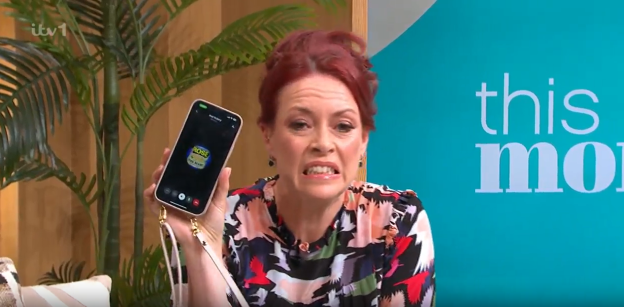 Screenshot of a woman holding up her phone showing a video call with a can of beans on the screen.