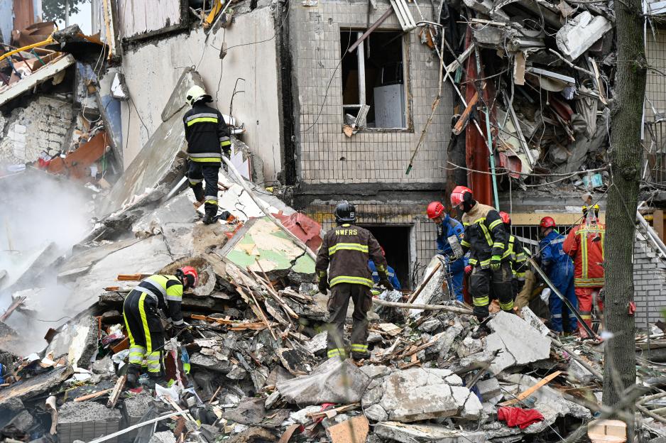 Emergency responders amidst the rubble of a damaged building.