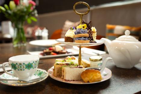 Afternoon tea set with pastries, sandwiches, and scones.