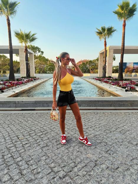 Christine McGuinness showing off her tan in a yellow top and denim shorts.