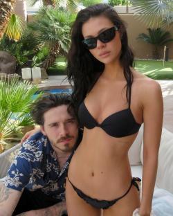 Brooklyn Beckham and Nicola Peltz in swimwear by a pool.