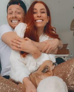a man and woman are hugging each other and the woman is wearing an engagement ring