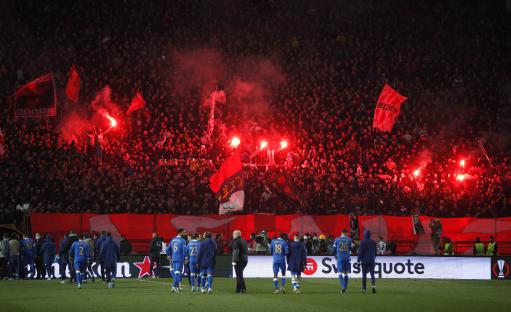 Crvena Zvezda fans with flares in the stands after a soccer match.