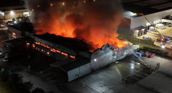 Huge blaze engulfs warehouse with smoke visible for miles as urgent warning issued to locals & firefighters battle fire