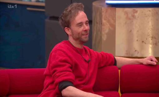 Man in red sweater on a red couch.
