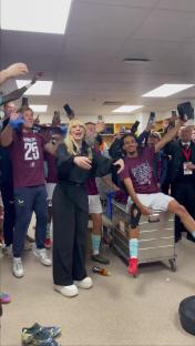 Burnley football players celebrating promotion with a singer.