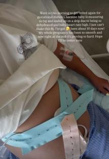 Pregnant person in hospital bed with IV and fetal monitor.