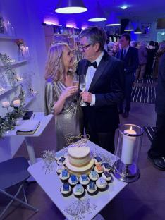 A bride and groom toast at their wedding reception in a bookstore.