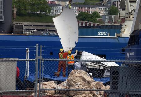 workers are working on a large blue ship with the letters eee on the side