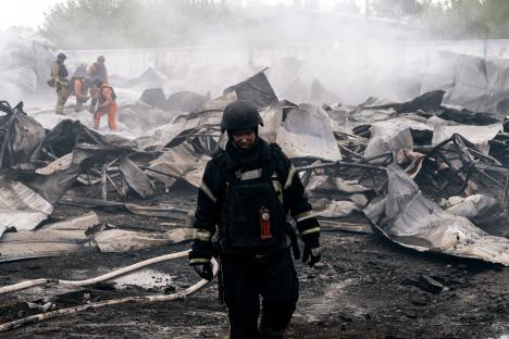 Firefighter surveying the damage to a building after a fire.