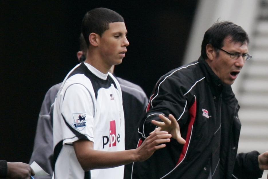 A young Fulham football player and his manager on the sidelines.
