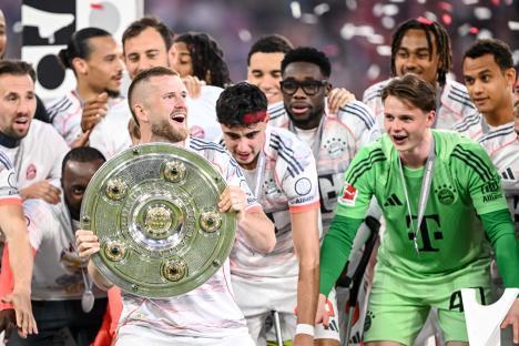 Eric Dier of Bayern Munich holding the Bundesliga championship trophy.