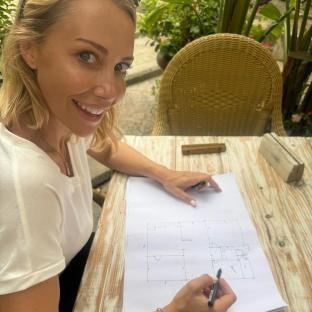 Woman drawing house plans outdoors.