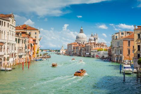 Boats on the Grand Canal in Venice, Italy, with Santa Maria Della Salute in the background.