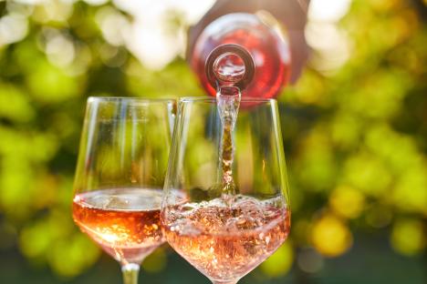 Rose wine being poured into two glasses.