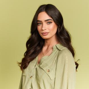 Woman with long brown hair wearing a sage green shirt.