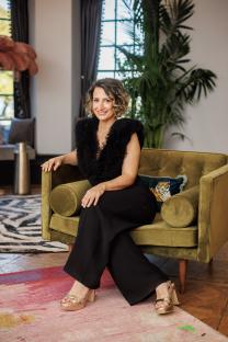 Woman in black outfit sitting on a green chair.