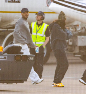 Three people walking on an airport tarmac.