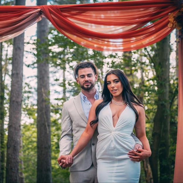 Erica Jordan from Married at First Sight and a man holding hands in a forest, standing under draped fabric.