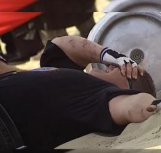 Strongman lying on the ground after a competition.