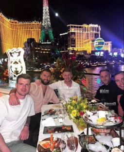 Four men seated at a table outdoors enjoying a seafood dinner in Las Vegas.