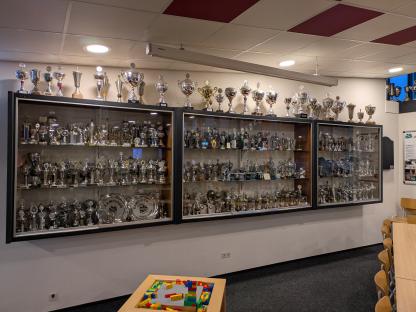Numerous trophies and awards displayed in glass cases.