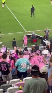 Lionel Messi walking down a soccer field tunnel to cheering fans.