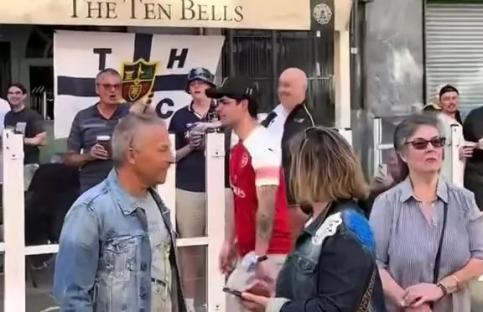 Arsenal fan confronted by Tottenham Hotspur supporters outside a pub.