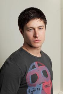 Headshot of a man wearing a dark gray t-shirt.