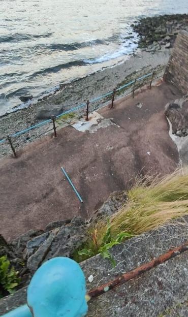 Collapsed sea railing near the water.