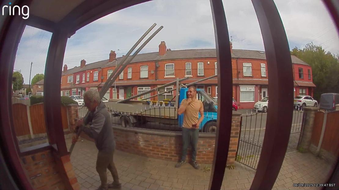 Ring doorbell camera footage showing construction workers placing scaffolding outside a house.
