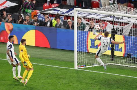 Micky van de Ven of Tottenham Hotspur clearing a goal-line shot.