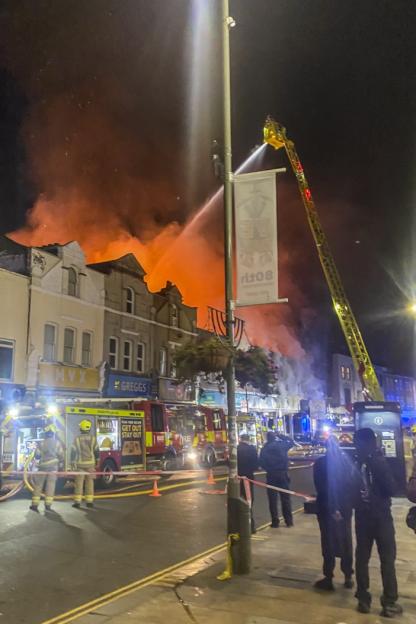 © Licensed to London News Pictures. 09/10/2025. London, UK. Fifteen fire engines and around 100 firefighters have been called around 4:30am to a fire on High Street in Penge. Firefighters tackle a fire in a two storey terraced shop where a large part of the ground floor is alight in Penge south east London. Photo credit: LNP