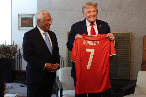 Donald Trump holding a signed Cristiano Ronaldo soccer jersey.