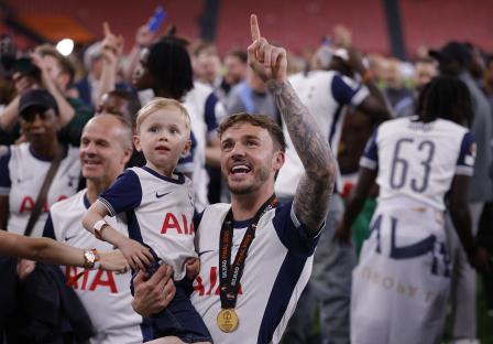 James Maddison of Tottenham Hotspur celebrates winning the Europa League with his son.
